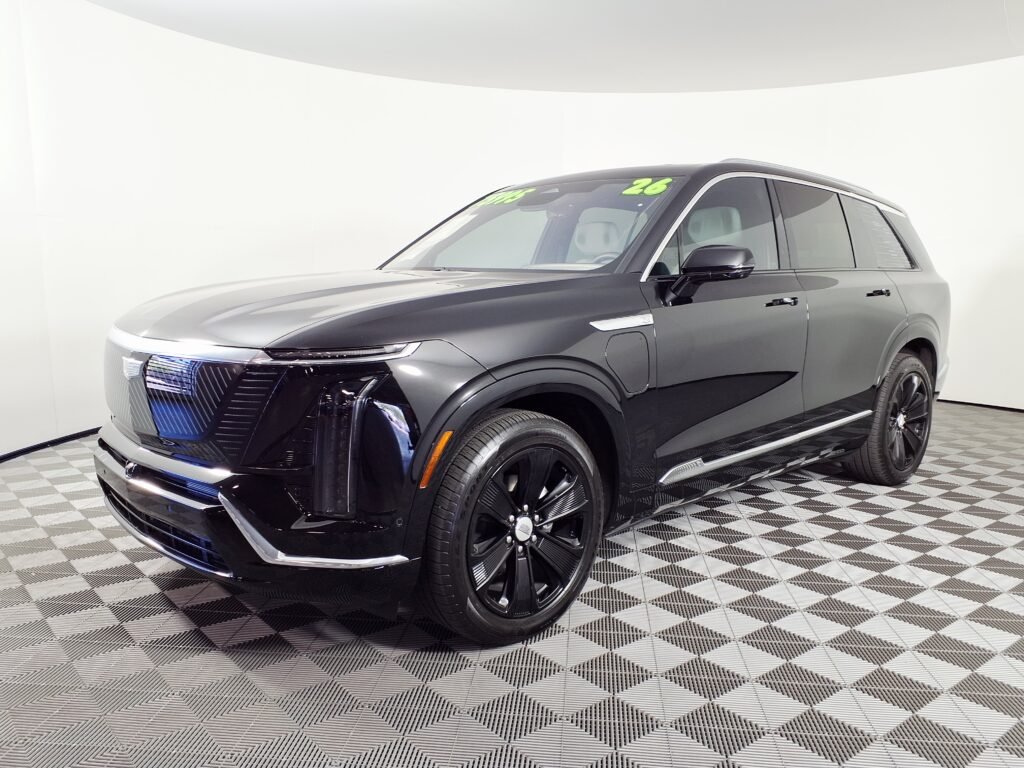 A dark-painted 2026 Cadillac VISTIQ, the three-row electric SUV, viewed from the front three-quarter angle.